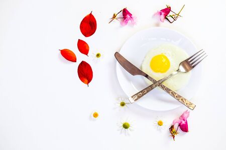 scrambled eggs on a white plate and a bright white table with additionsの写真素材