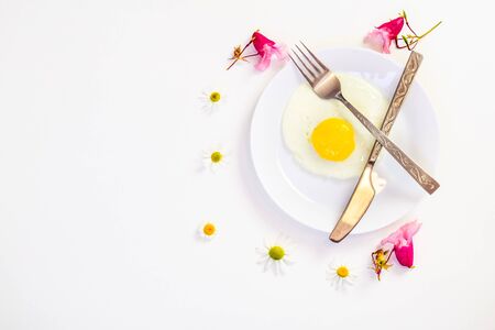 scrambled eggs on a white plate and a bright white table with additionsの写真素材