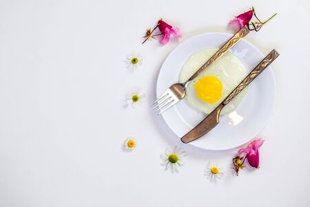 scrambled eggs on a white plate and a bright white table with additionsの写真素材