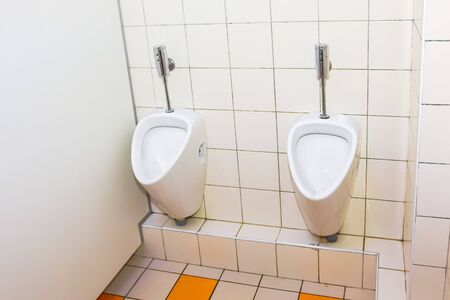 toilet with a number of urinals in a theater or restaurantの写真素材