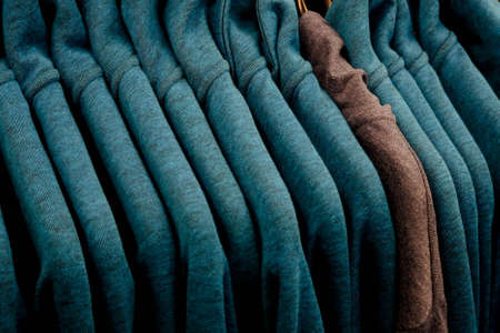clothes of the same color on a hanger in a storeの写真素材