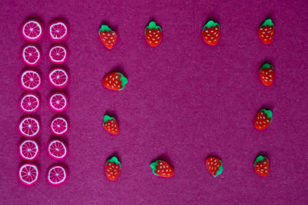 miniature fruits and berries on a red or crimson backgroundの写真素材