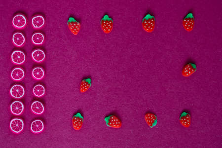miniature fruits and berries on a red or crimson backgroundの写真素材