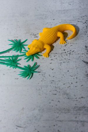bright yellow toy crocodile in an unusual situationの写真素材