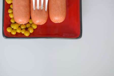 sausages with green peas on a plate