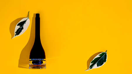 women's cosmetics with plant leaves on a yellow backgroundの写真素材