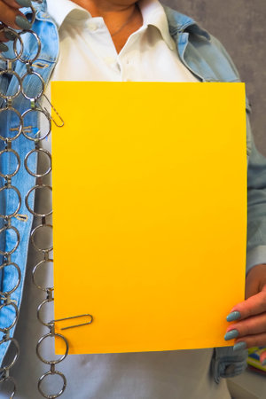 woman holds a paper sheet in her hands with a bright manicureの写真素材