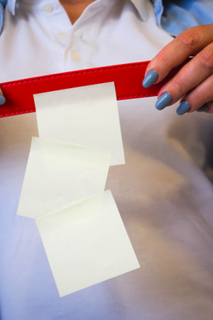 woman holds a paper sheet in her hands with a bright manicureの写真素材