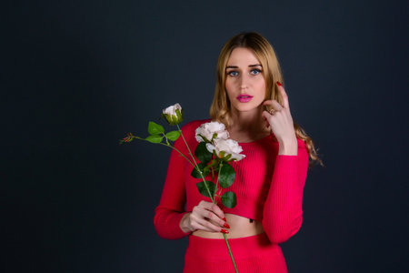 Portrait of a beautiful girl in a red dress with a bouquet of white rosesの写真素材
