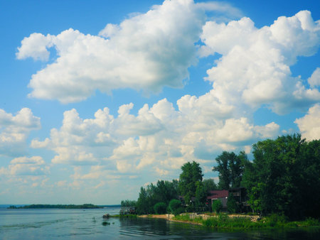 Beautiful summer landscape on the river and blue sky with white cloudsの写真素材