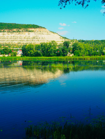 Beautiful summer landscape with lake, forest and blue sky background.の写真素材