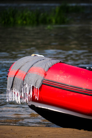 Red inflatable boat on the river bank, close-up.の写真素材