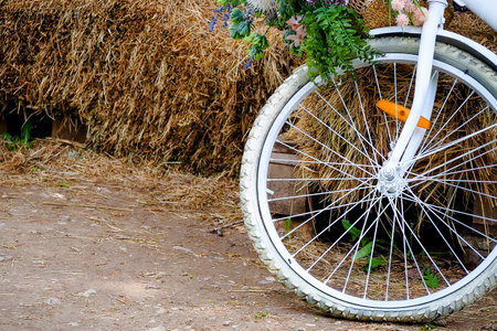 White bicycle on the ground with straw bales in the background.の写真素材