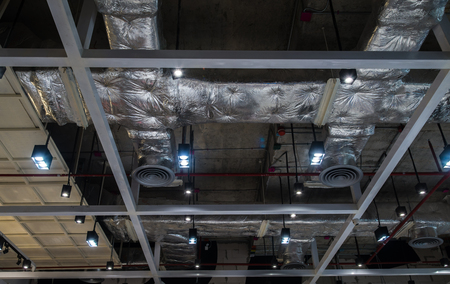 Ventilation system pipes on the ceiling of a modern factory plant building.の写真素材