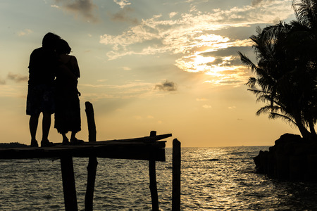 Silhouettes at sunset on the beach.の写真素材