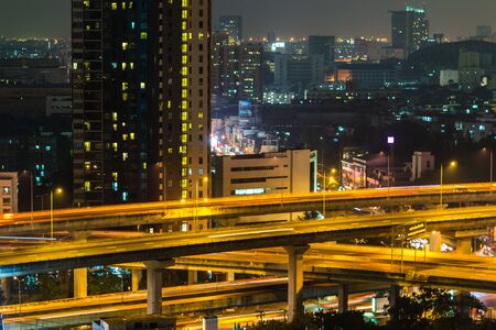 a view over the big asian city of Bangkok , Thailand at nighttime when the tall skyscrapers are...