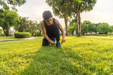 young man runner tying shoelacesの写真素材