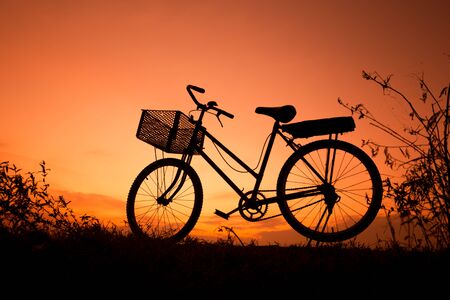 Old Bicycle silhouette at sunset, Landscape picture Bike at orange skyの写真素材