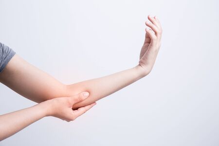 Asian woman with elbow pain on white backgroundの写真素材