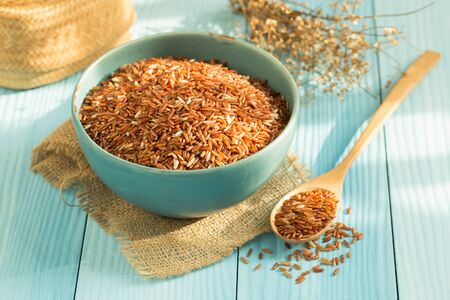 Organic rice grain in a blue bowl, Rice Mun Pu variety,Photo by natural lightの写真素材