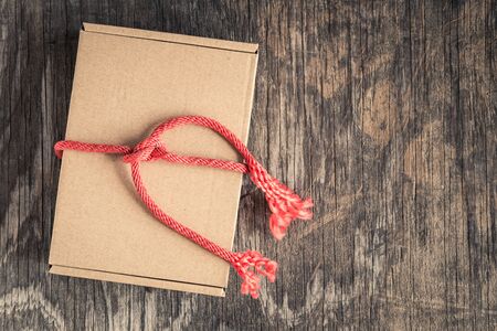 Gift box with red rope on old wood table,top viewの写真素材