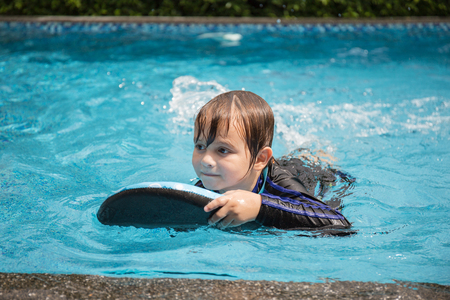 Boy playing in outdoor swimming pool,Kids learn to swim.の写真素材