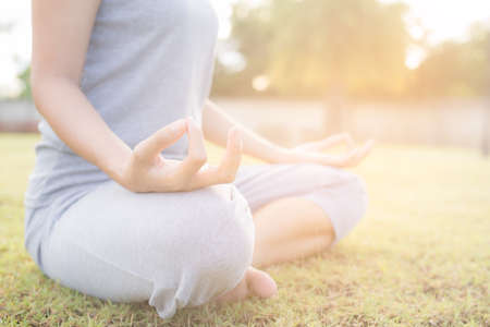 Close up hands woman do yoga,Asian girl doing yoga in garden with morning light