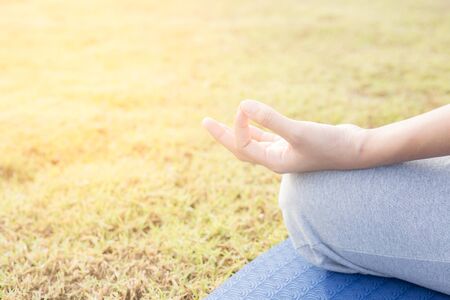 Close up hands woman do yoga,Asian girl doing yoga in garden with morning lightの写真素材
