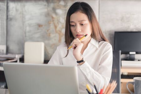New generation business woman is working with a notebook,Asian female are stressed working in the officeの写真素材