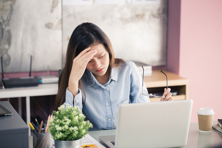 Young business people are suffering from headaches,Asian women Stressful Working with a notebook for a long time,Office syndrome conceptの写真素材