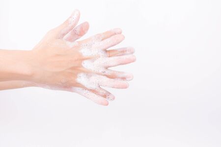 Asian girl hands are washing with soap bubbles on white background
