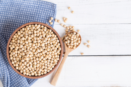 White wood floor with wooden cup with soybean,top view and copyspace,soybeans in wooden bowl with wooden spoon on table woodenの写真素材