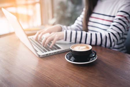 Coffee latte art in coffee shop on blurred background from business womanの写真素材