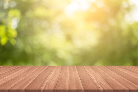Empty wood table top on nature green blurred background at garden,space for montage show productsの写真素材