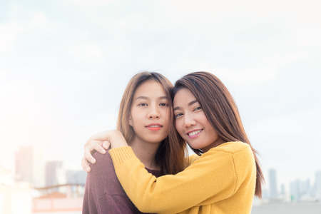 Couple of young asian women on top of building with happiness moment, lesbian couple concept