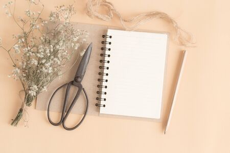 flat lay image of workplace with empty notebook,Yellow paper ground with notebook with pencil and...
