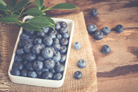 Blueberry in a white bowl on wood tableの写真素材