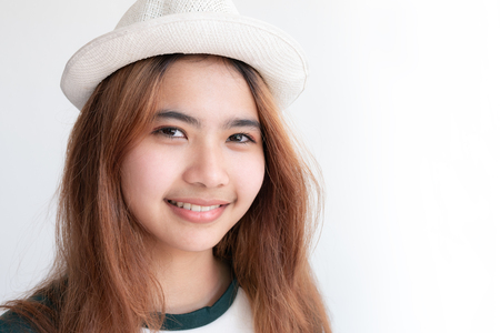 Asian girl wearing white hat smiling,Hipster young girl with smile on white backgroundの写真素材