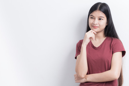 Asian women are standing and thinking on white background.の写真素材