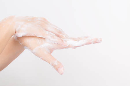 Asian woman hands are washing with soap bubbles on white backgroundの写真素材