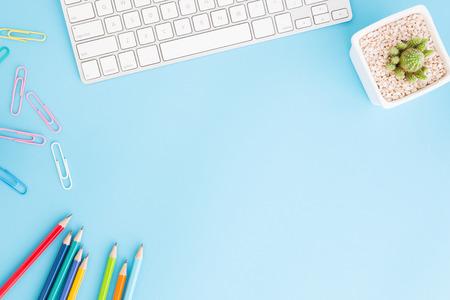 Flat lay photo of office desk with pencil and keyboard ,Top view workpace on blue background and...