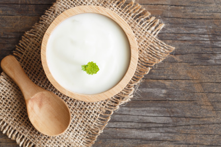 top view of natural greek yogurt in cup on old wooden table background. Yogurt is delicious tasty and healthyの写真素材