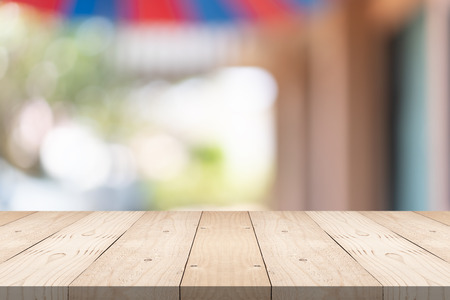 Empty brown wood table top on blur background at shopping mall, copy space for montage you productの写真素材