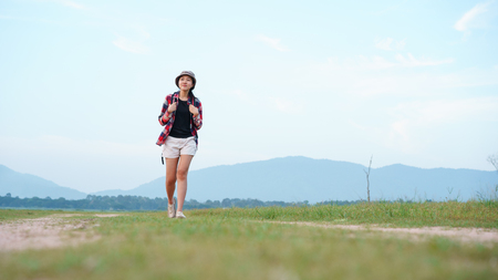 Asian young woman tourist backpack walk travel in the nature forest. Woman tourist walking in the nature on background mountain view.の写真素材