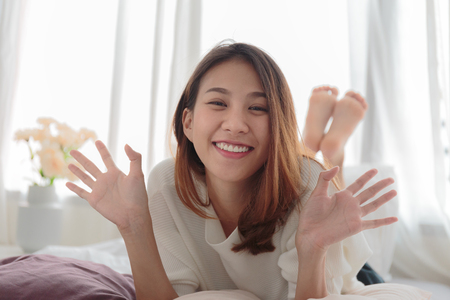 Portrait of beautiful smiling woman in bed at homeの写真素材