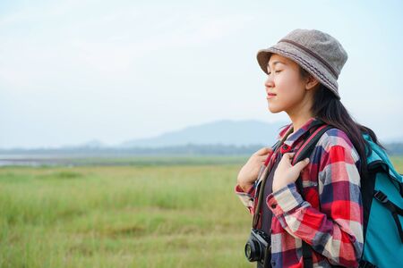 Asian women are closing their eyes and enjoying nature on the mountains and sky background. A young...