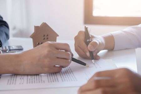 Salesmen are letting the male customers sign the sales contract, Asian women and men are doing business in the office, Business concept and contract signingの写真素材