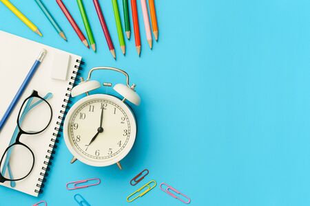Flat lay photo of office desk with colorful pencil, Paper clip, Glasses, Note book, White retro...