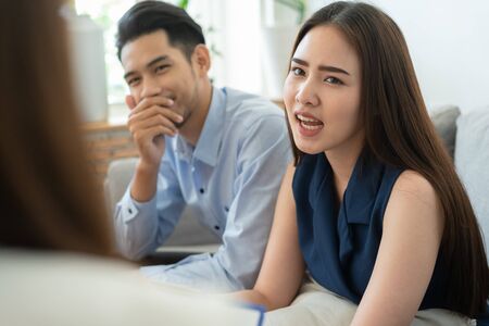 Asian couple sitting on the couch in the room to consult mental health problems by doctor, Health and illness conceptsの写真素材