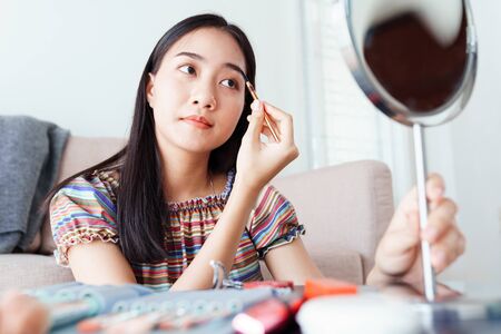 Beauty blogger of Asian female tutorial makeup cosmetics live broadcasts video streaming, Beautiful influencers are recommending to use eyebrow brush for beauty, concept online learningの写真素材